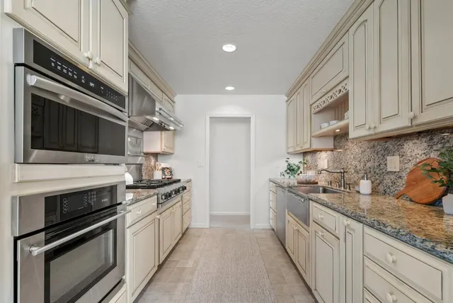 a kitchen with stainless steel appliances granite countertop a stove and a microwave