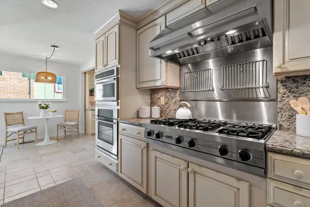 a kitchen with granite countertop a stove and a sink