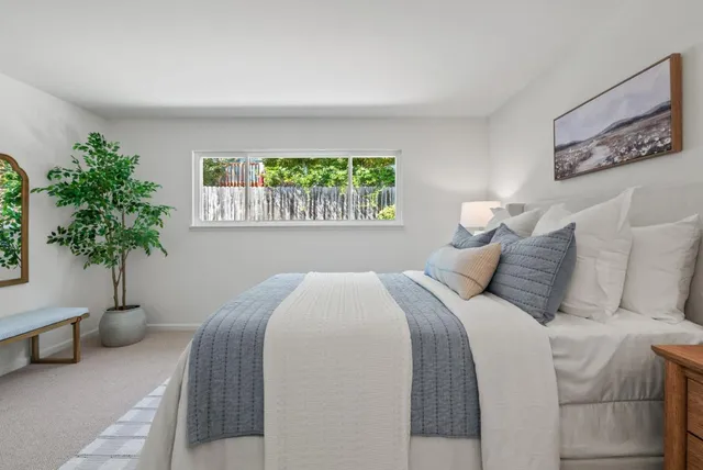 a bedroom with a large bed and a potted plant
