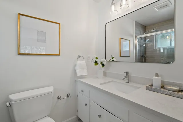 a bathroom with a toilet sink and mirror