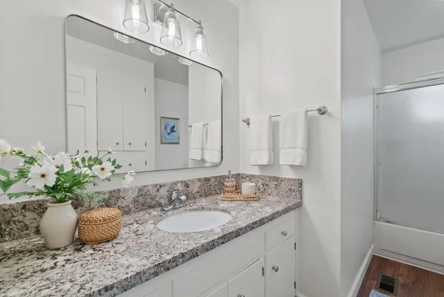 a bathroom with a granite countertop sink and a mirror