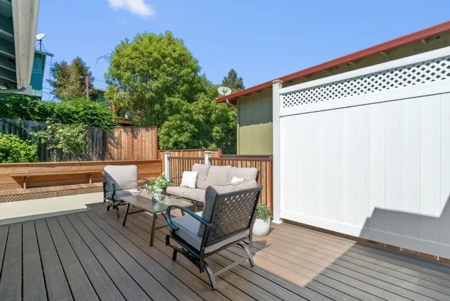 an outdoor sitting area with furniture and wooden floor