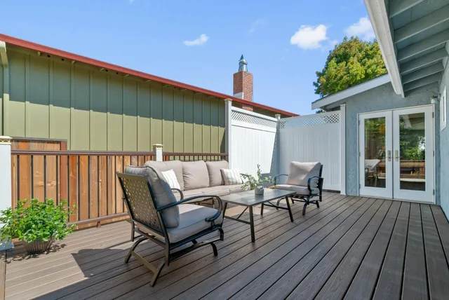a balcony with wooden floor table and chairs