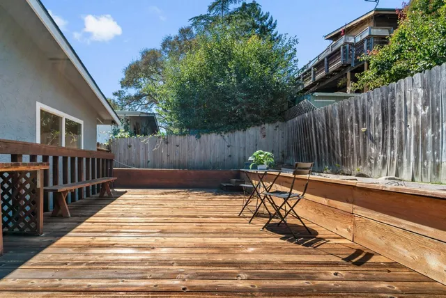 a view of a patio with a table and chairs with wooden fence