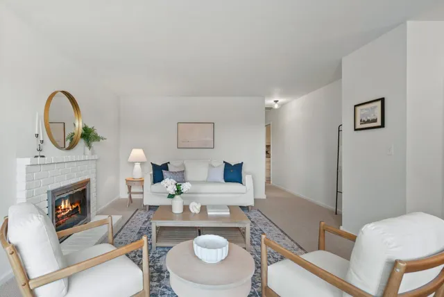 a living room with furniture a fireplace and a table