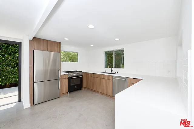 a kitchen with granite countertop white cabinets and stainless steel appliances