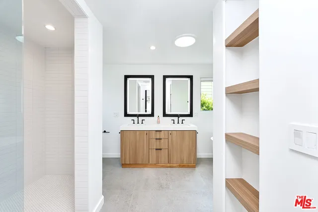a bathroom with a double vanity sink mirror and bathtub