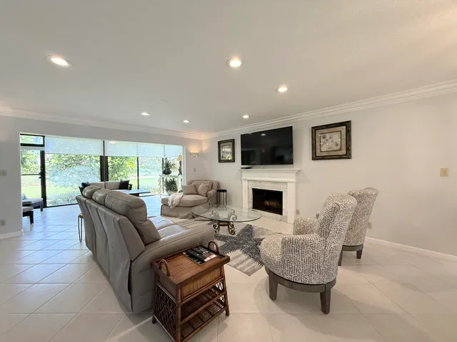 a living room with furniture a fireplace and a large window