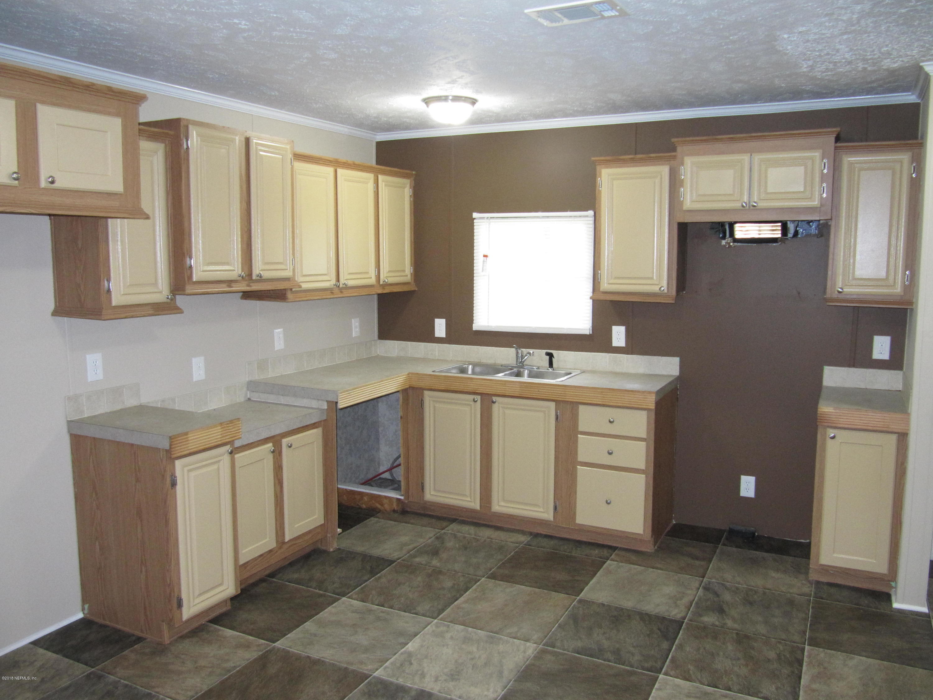 110 Putnam Loop Road Melrose, FL 32666 - Photo 3 of 7 a kitchen with a stove sink and cabinets