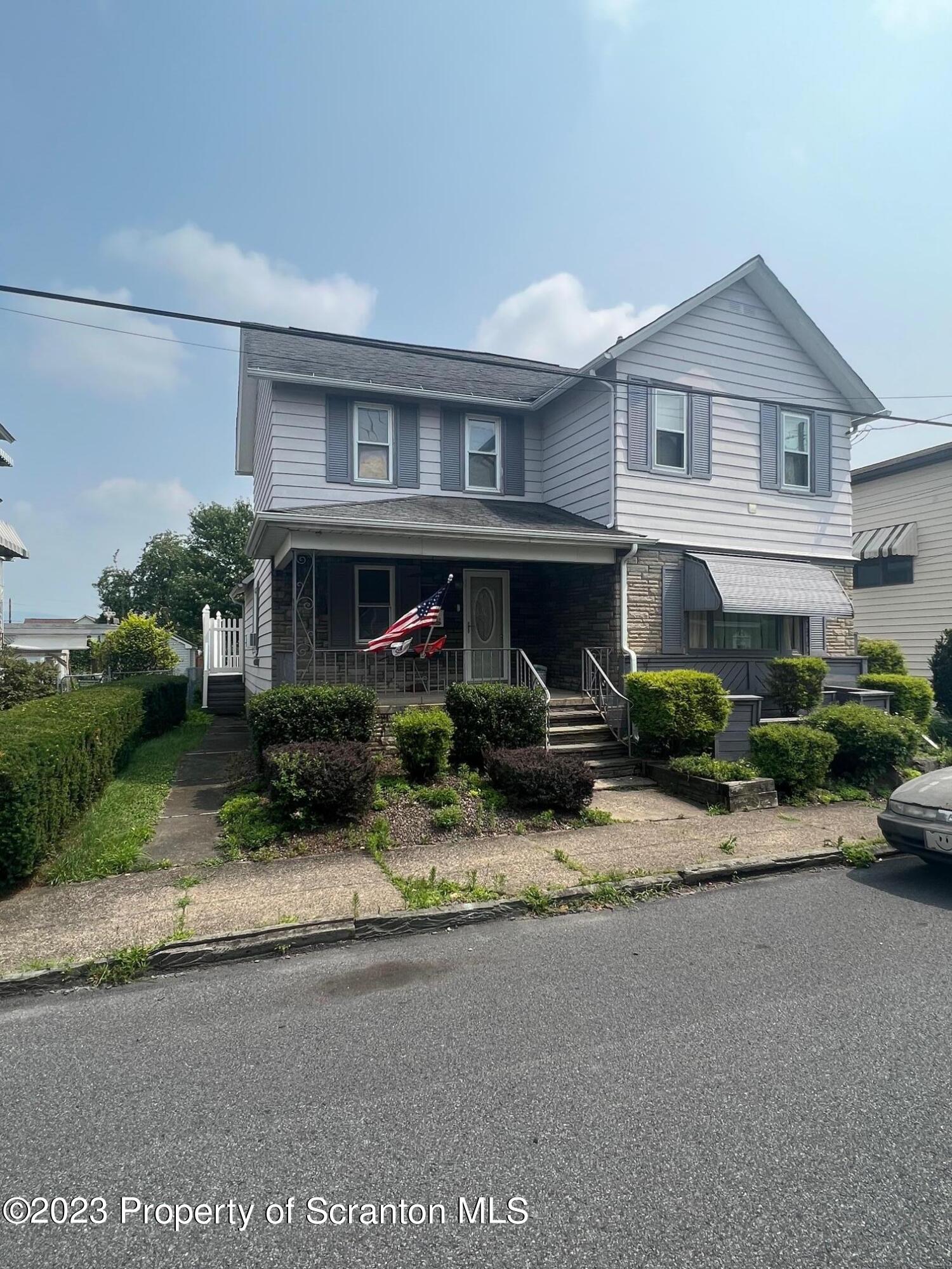 a view of house with yard and sitting area