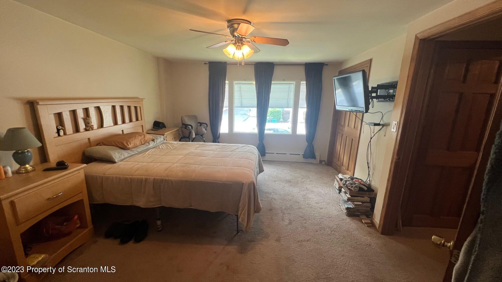 526 George Street Old Forge, PA 18518 - Photo 11 of 43 a spacious bedroom with a bed and a chandelier