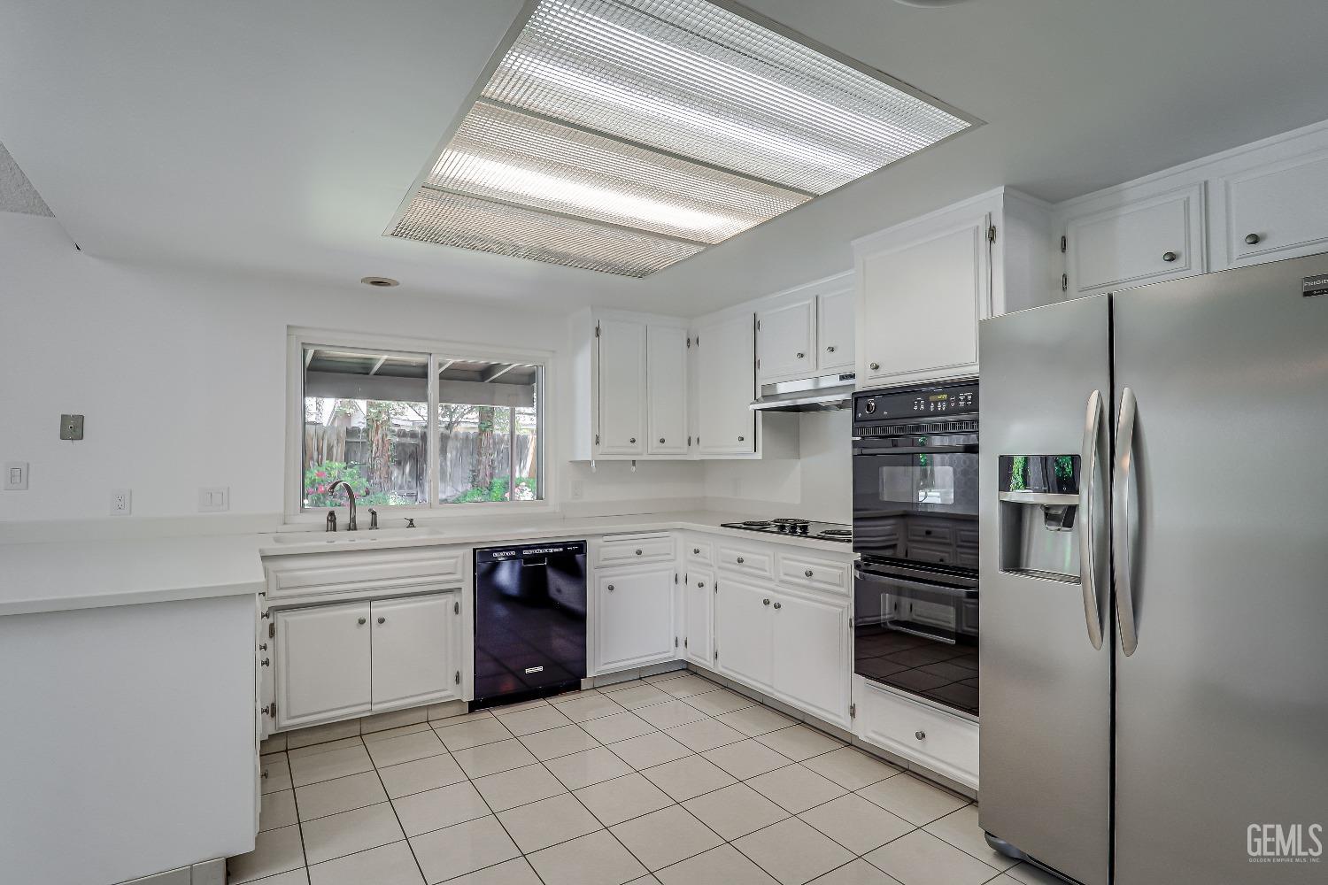 Undisclosed Address Bakersfield, CA 93309 - Photo 14 of 34 a kitchen with white cabinets and stainless steel appliances