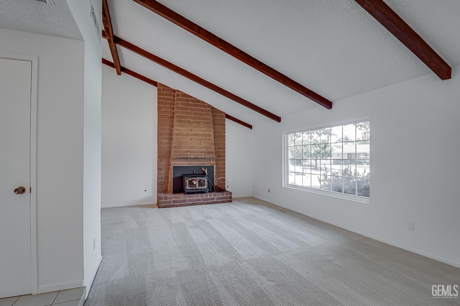 Undisclosed Address Bakersfield, CA 93309 - Photo 7 of 34 a view of an empty room with a fireplace and a window