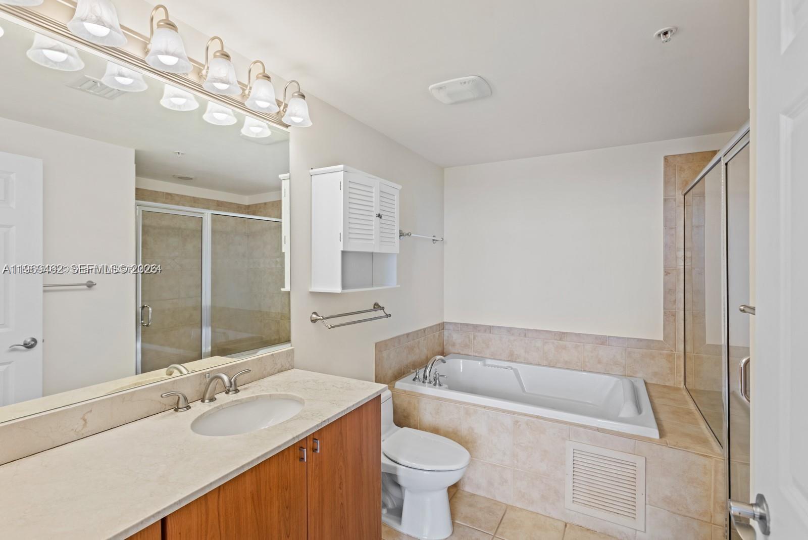 888 Douglas Road, Unit 1405 Coral Gables, FL 33134 - Photo 15 of 42 a bathroom with a granite countertop sink a toilet a mirror and bathtub