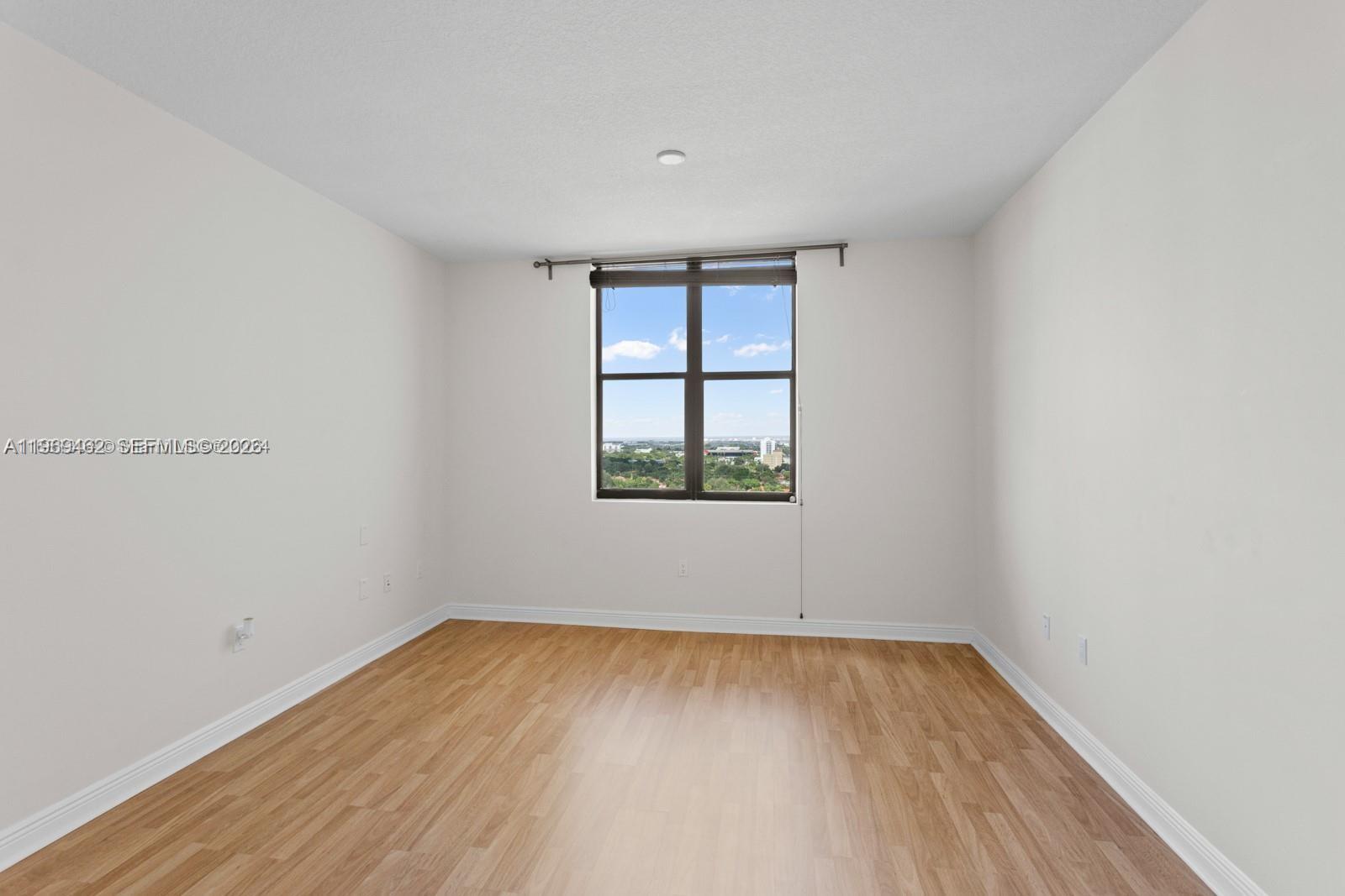 888 Douglas Road, Unit 1405 Coral Gables, FL 33134 - Photo 16 of 42 wooden floor in an empty room with a window