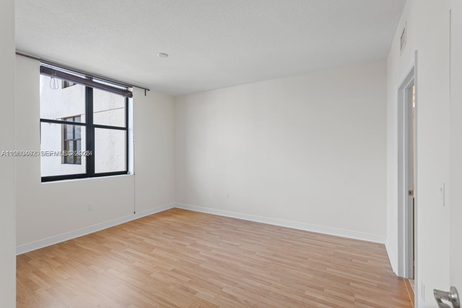 888 Douglas Road, Unit 1405 Coral Gables, FL 33134 - Photo 17 of 42 wooden floor in an empty room with a window