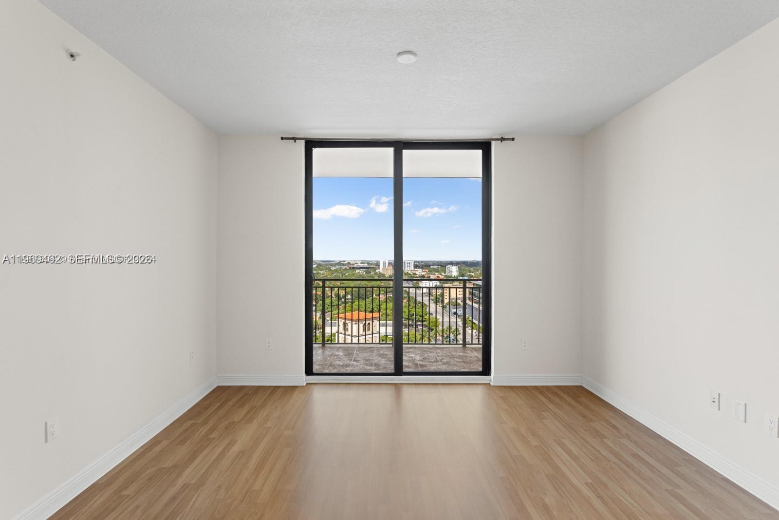 888 Douglas Road, Unit 1405 Coral Gables, FL 33134 - Photo 18 of 42 wooden floor in an empty room with a window