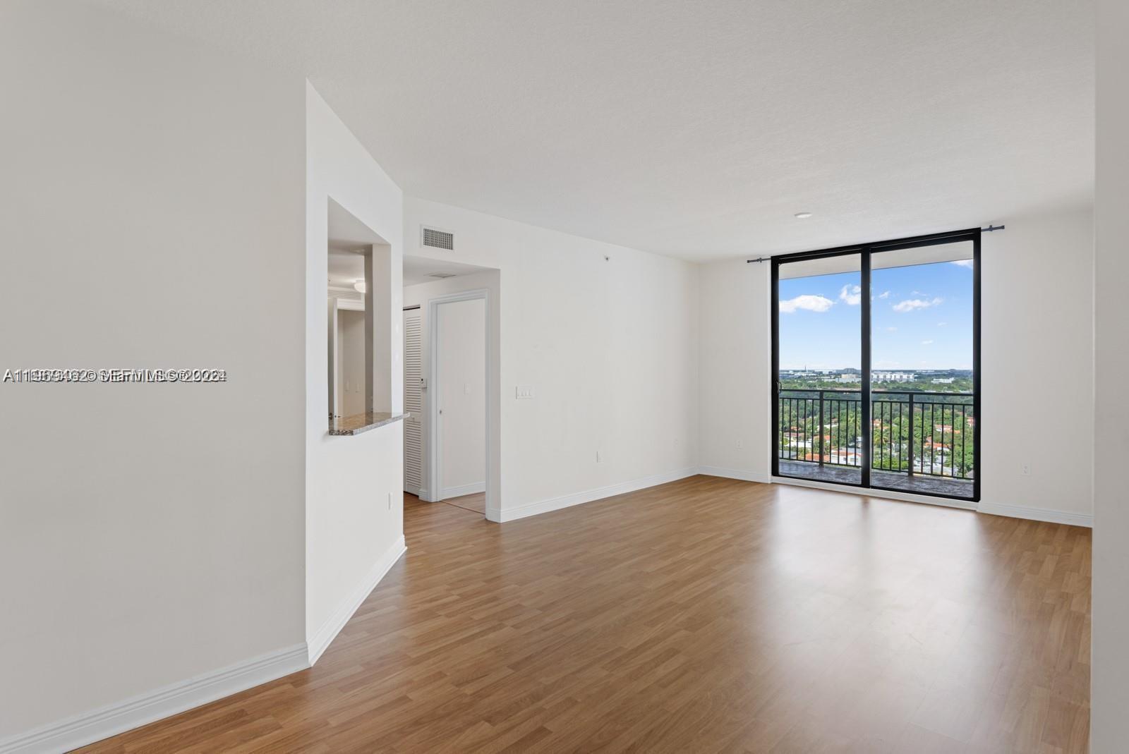 888 Douglas Road, Unit 1405 Coral Gables, FL 33134 - Photo 2 of 42 a view of an empty room with wooden floor and a window