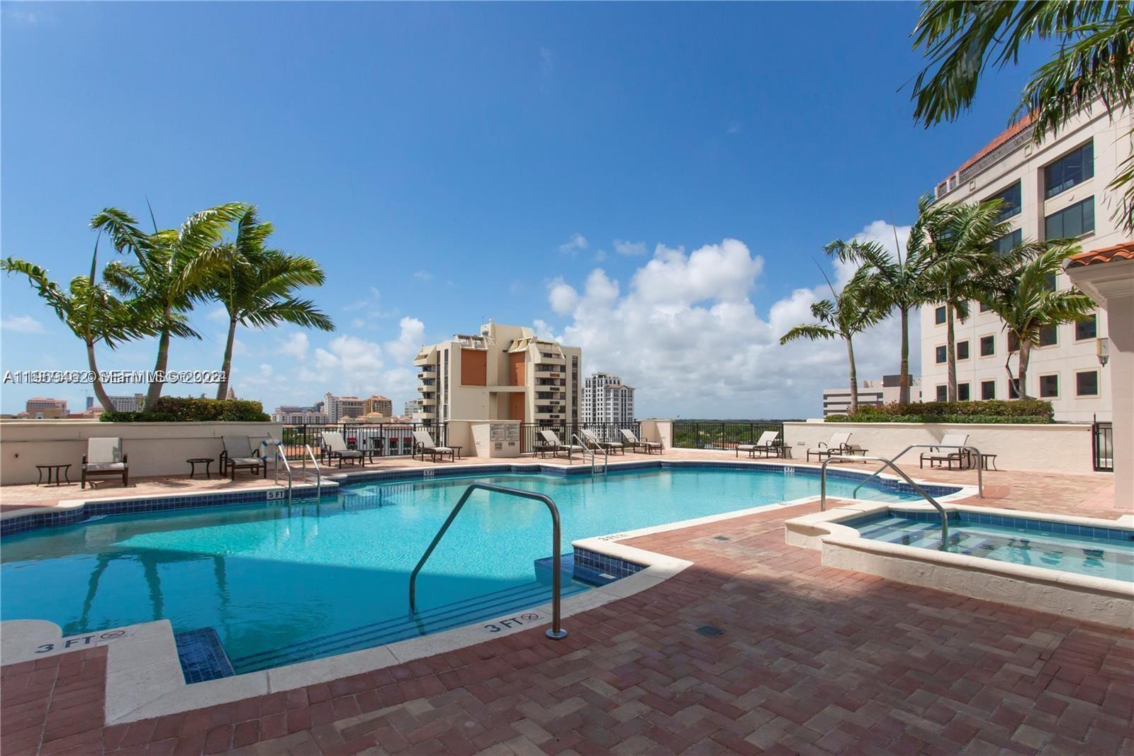 888 Douglas Road, Unit 1405 Coral Gables, FL 33134 - Photo 32 of 42 a view of a swimming pool with a lounge chairs