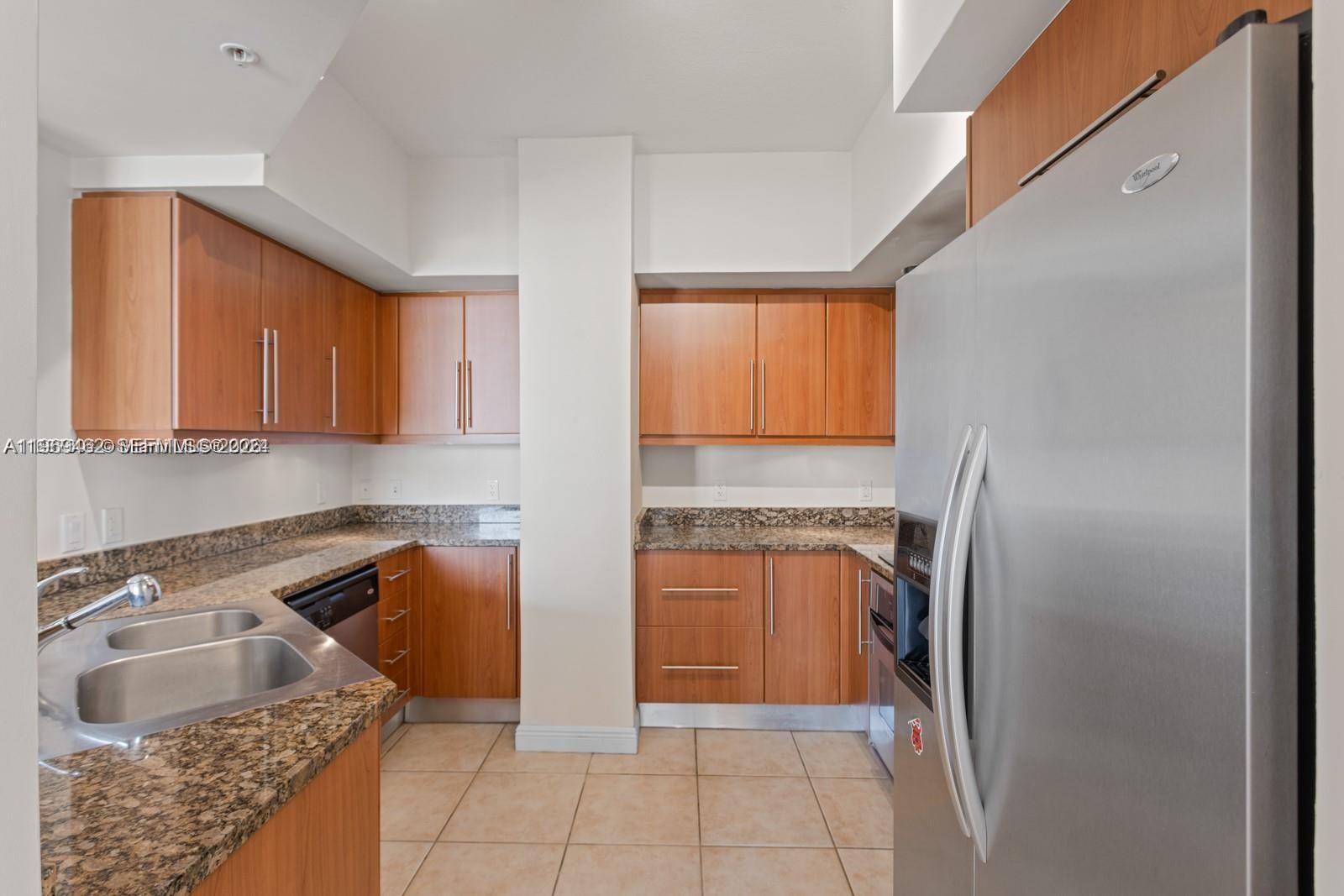 888 Douglas Road, Unit 1405 Coral Gables, FL 33134 - Photo 4 of 42 a kitchen with stainless steel appliances granite countertop a refrigerator and a sink