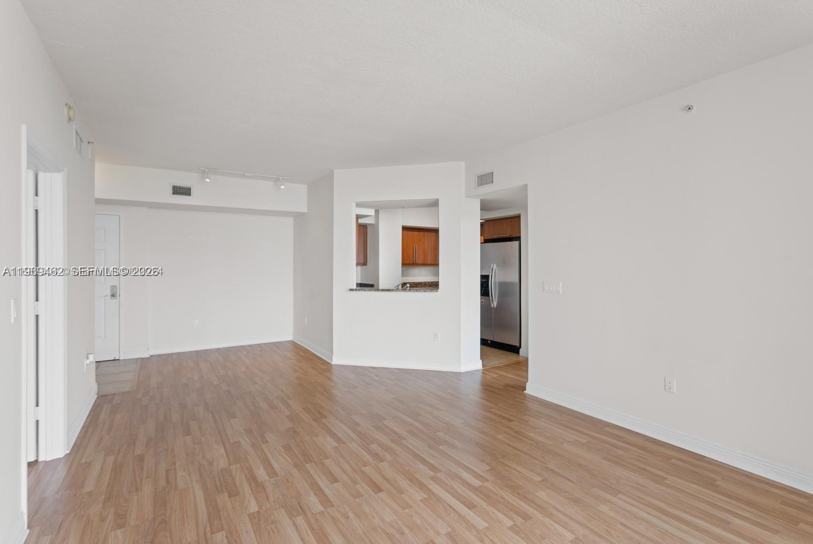 888 Douglas Road, Unit 1405 Coral Gables, FL 33134 - Photo 8 of 42 an empty room with wooden floor and windows