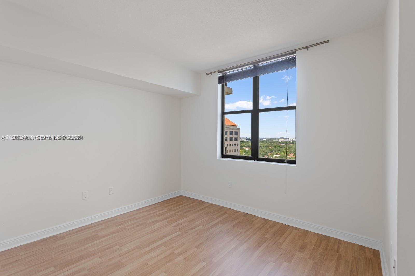 888 Douglas Road, Unit 1405 Coral Gables, FL 33134 - Photo 9 of 42 wooden floor in an empty room with a window