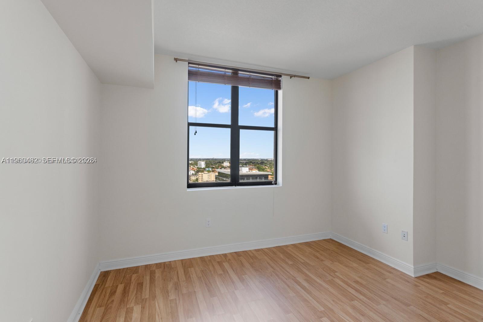 888 Douglas Road, Unit 1405 Coral Gables, FL 33134 - Photo 10 of 42 a view of an empty room with wooden floor and a window