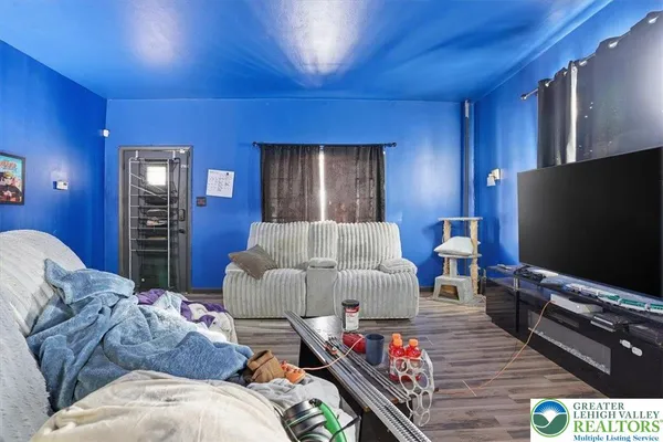 a living room with furniture a flat screen tv and closet