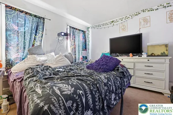 a view of bedroom with furniture and flat screen tv