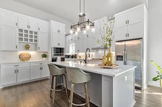 a kitchen with center island cabinets stainless steel appliances and a chandelier