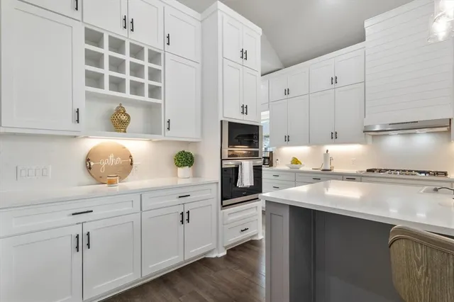 a kitchen with white cabinets and appliances