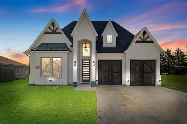 a front view of a house with a yard and garage