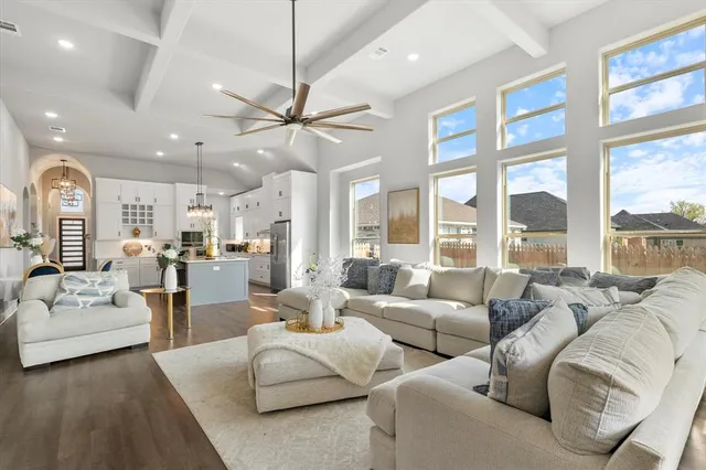 a living room with furniture ceiling fan and a large window