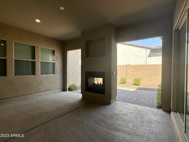 a view of an empty room with a fireplace and a window