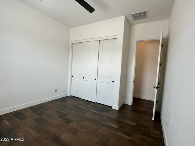 an empty room with closet and wooden floor