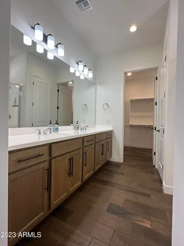 a spacious bathroom with a double vanity sink a mirror and a shower