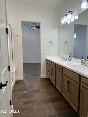a spacious bathroom with double vanity and a mirror