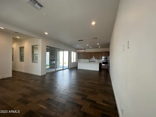 a view of a big room with wooden floor and a kitchen