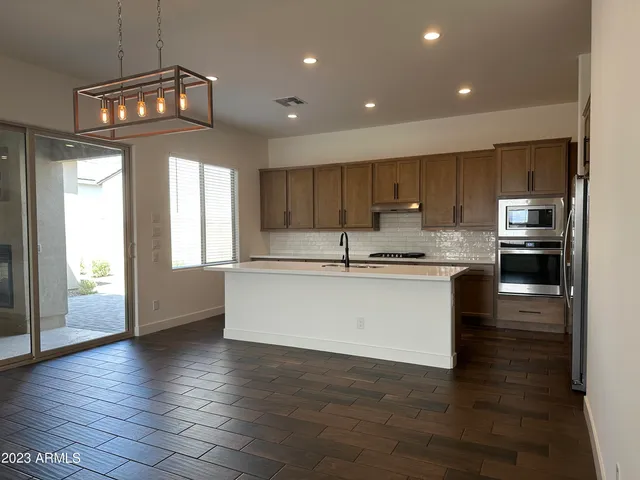 a kitchen with granite countertop wooden floors and wide window