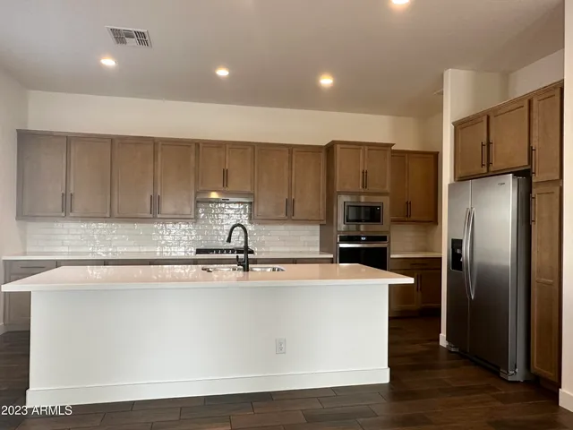 a kitchen with kitchen island a sink and refrigerator