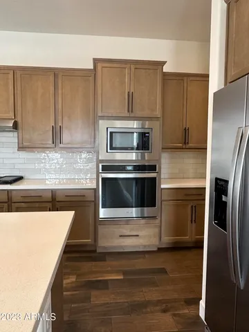 a kitchen with granite countertop a refrigerator stove and oven