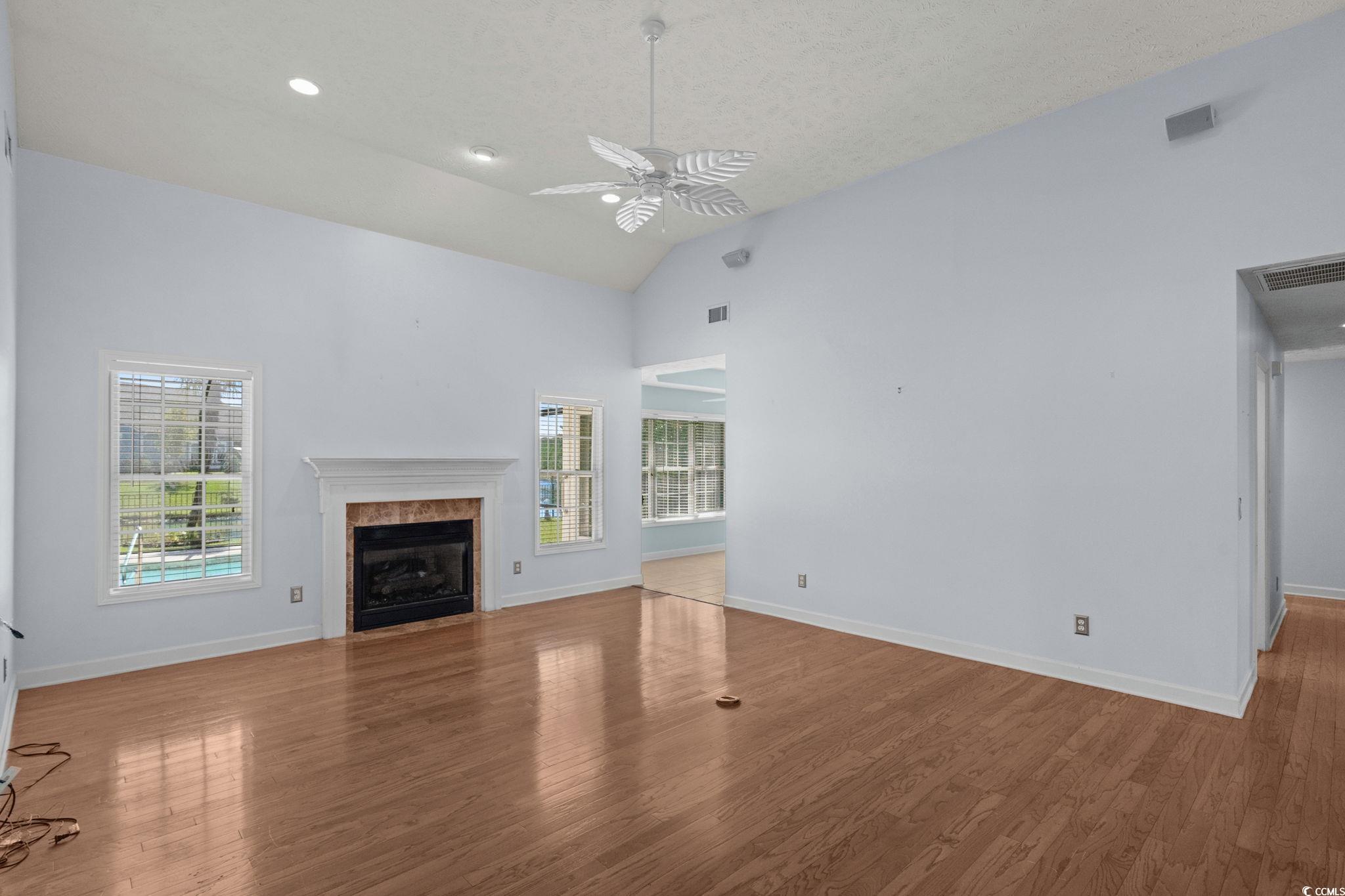 613 Broad River Road Myrtle Beach, SC 29588 - Photo 11 of 40 Unfurnished living room featuring wood finished floors, high vaulted ceiling, ceiling fan, a fireplace, and recessed lighting