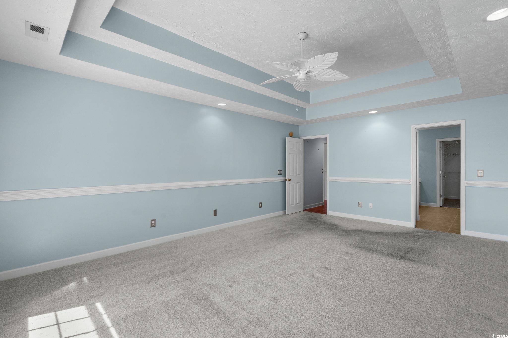 613 Broad River Road Myrtle Beach, SC 29588 - Photo 23 of 40 Unfurnished bedroom with carpet flooring, a tray ceiling, and a ceiling fan