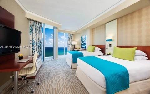 18001 Collins Avenue, Unit 2209 Sunny Isles Beach, FL 33160 - Photo 15 of 27 a living room with furniture a flat screen tv and a fireplace