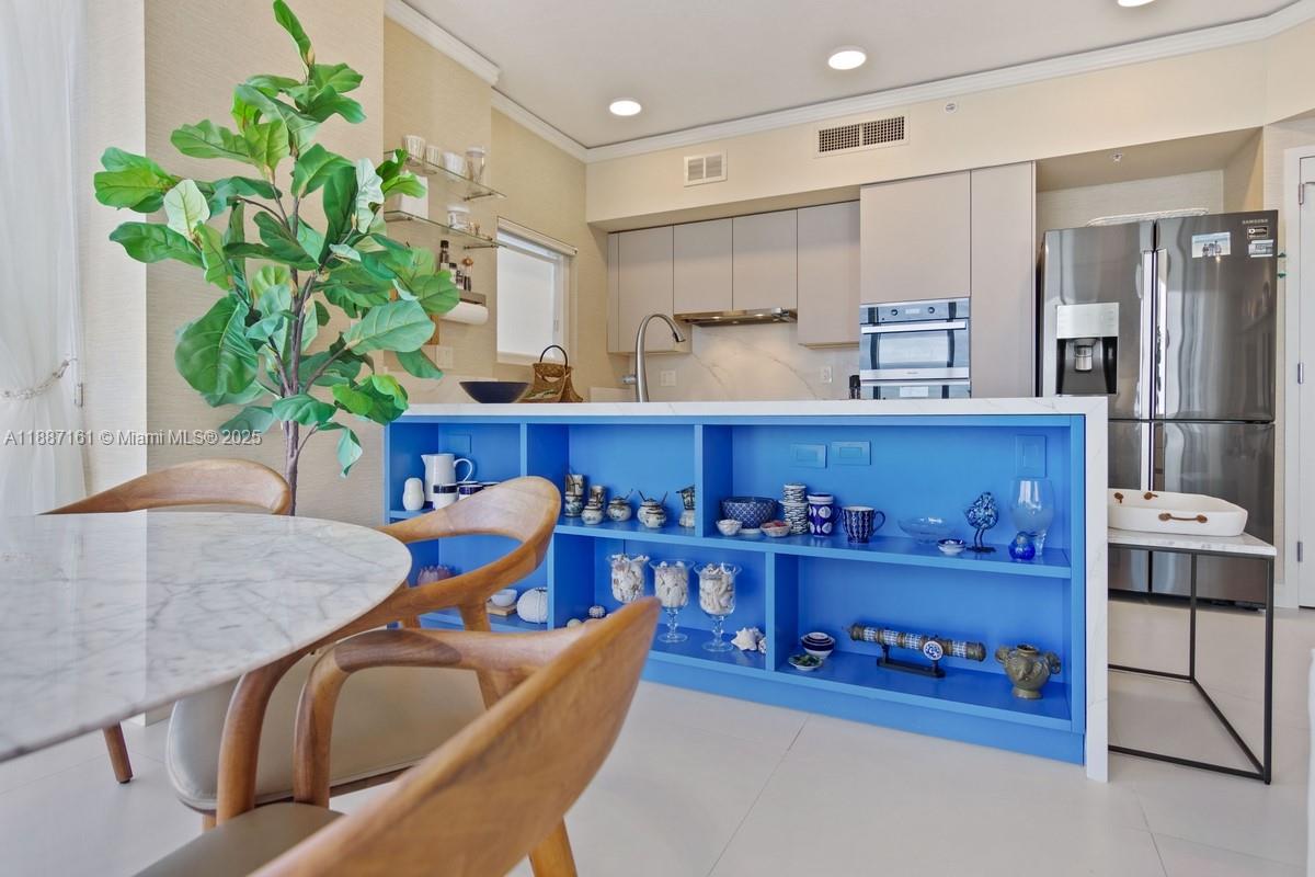 18001 Collins Avenue, Unit 2209 Sunny Isles Beach, FL 33160 - Photo 8 of 27 a kitchen with stainless steel appliances granite countertop a refrigerator and a wooden cabinets