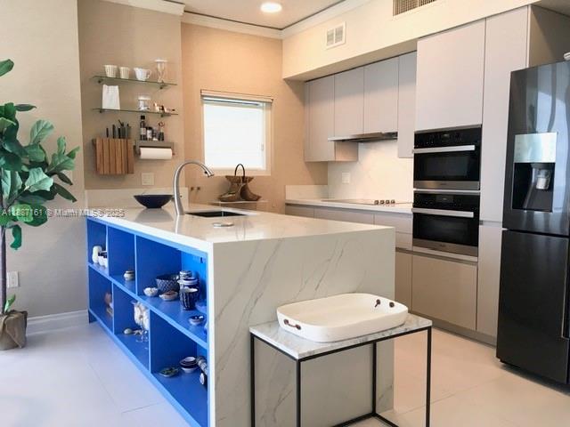 18001 Collins Avenue, Unit 2209 Sunny Isles Beach, FL 33160 - Photo 10 of 27 a kitchen with stainless steel appliances a sink cabinets and wooden floor