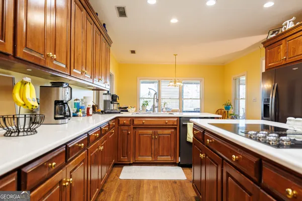 a kitchen with stainless steel appliances granite countertop a refrigerator and a stove top oven