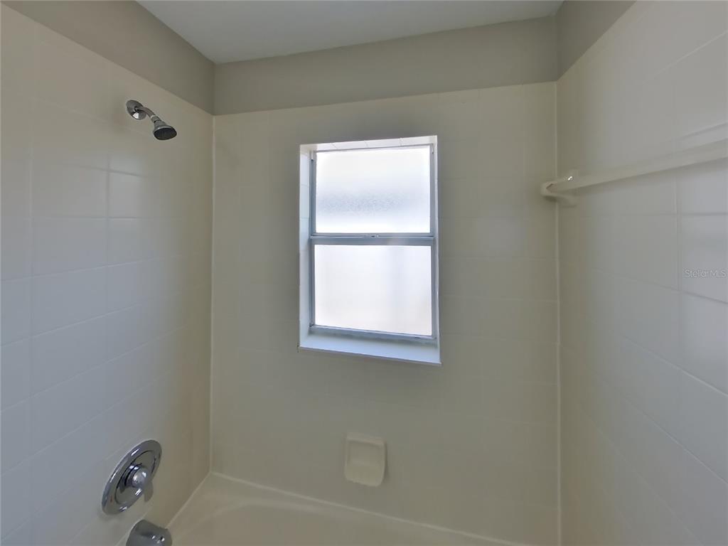 Undisclosed Address Riverview, FL 33578 - Photo 14 of 15 a bathroom with a bathtub a shower and a window