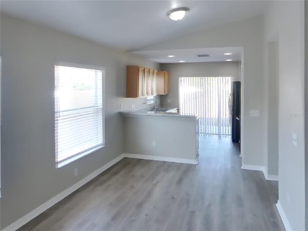 Undisclosed Address Riverview, FL 33578 - Photo 4 of 15 a view of kitchen and empty room with wooden floor
