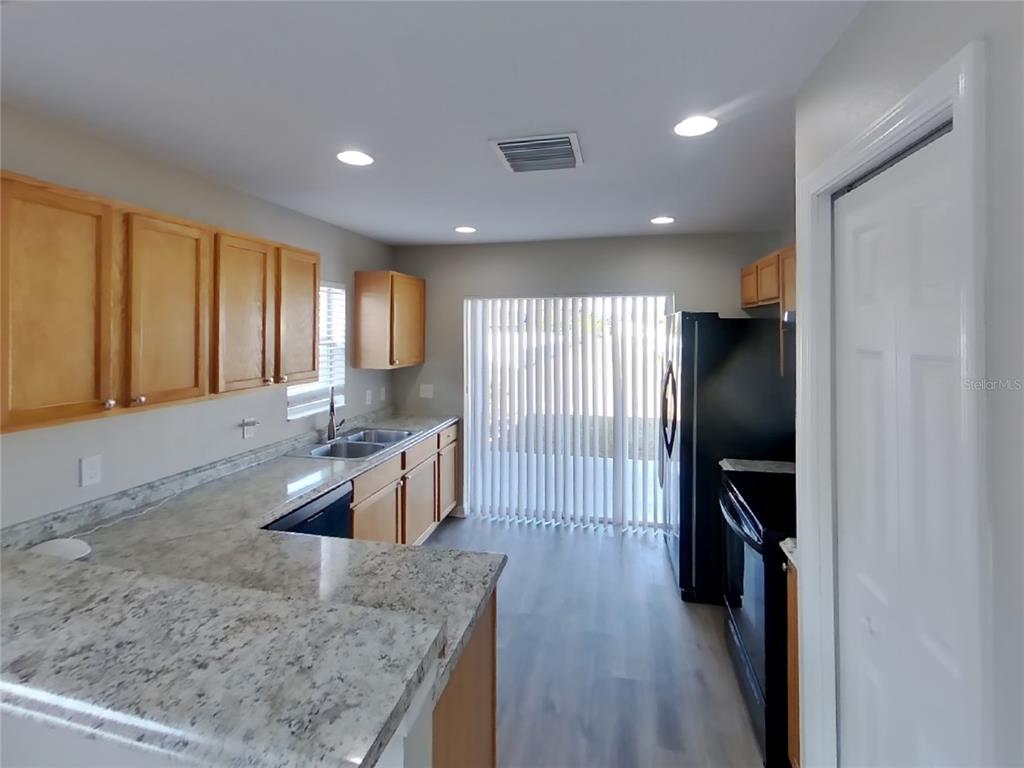 Undisclosed Address Riverview, FL 33578 - Photo 5 of 15 a large kitchen with a center island wooden floor and stainless steel appliances